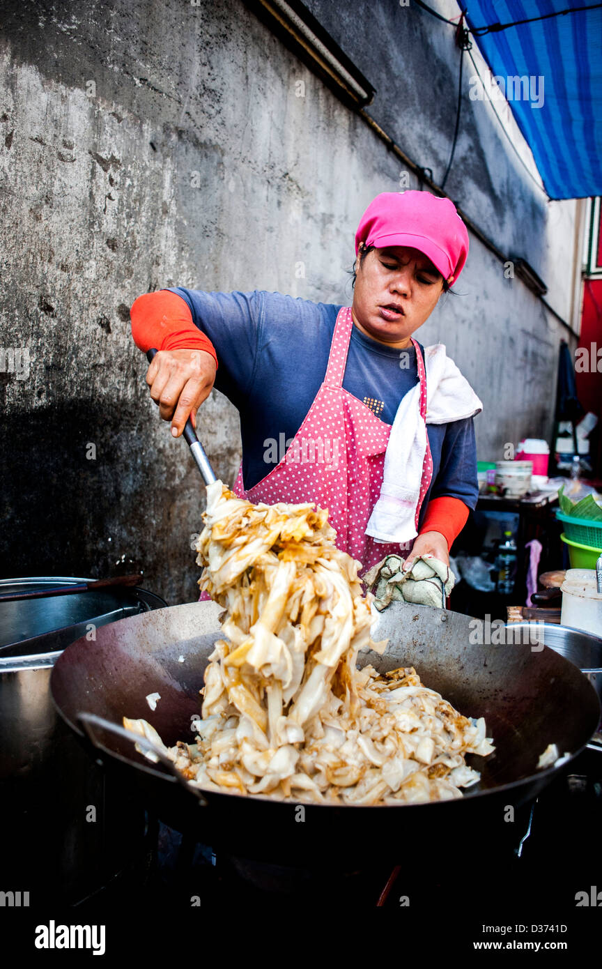 BANGKOK - THAILANDIA: una donna cuochi nel mercato di Chinatown a Bangkok Foto Stock