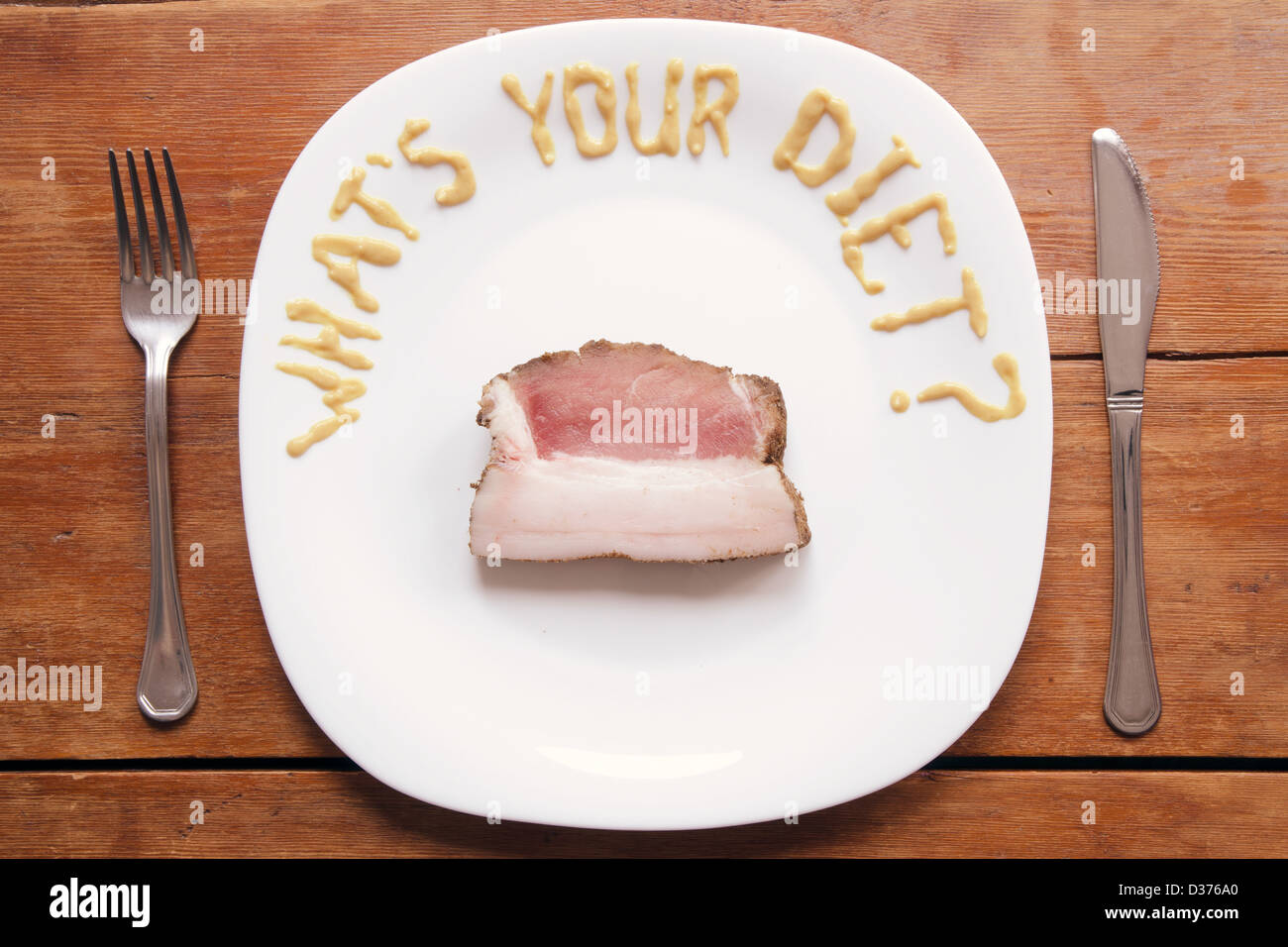 Umorismo domanda scritta da mostarda sulla piastra bianca con una spessa fetta di carne di maiale cruda Foto Stock