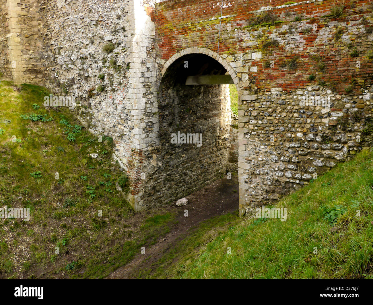 Un arco attraverso primi mote e bailey o anello opera del castello di Framlingham, Suffolk, Regno Unito Castello Normanno Foto Stock