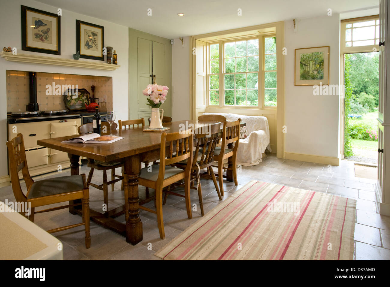 Una tradizionale casa colonica in stile con cucina aga cooker. Porta aperta sul giardino. Foto Stock