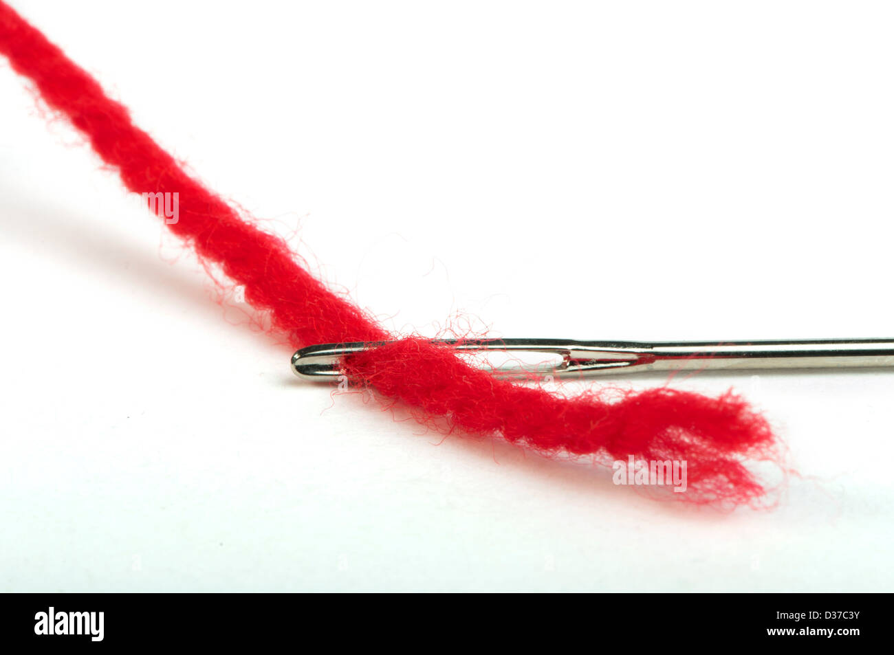 Ago di cucitura e filo rosso vicino. Isolato bianco . Foto Stock