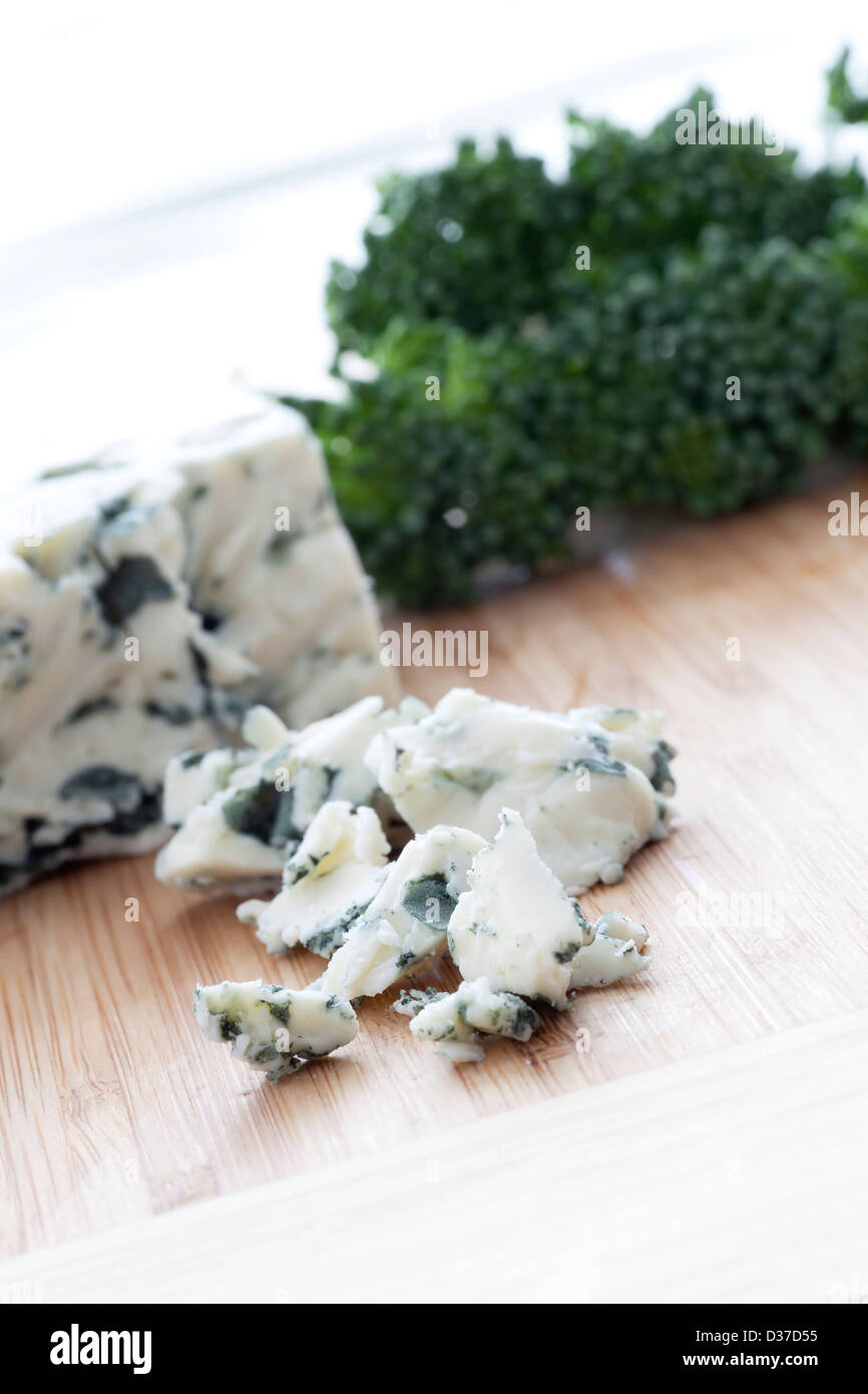 Sbriciolate il formaggio blu con blocco di formaggio e i broccoli in background. Foto Stock