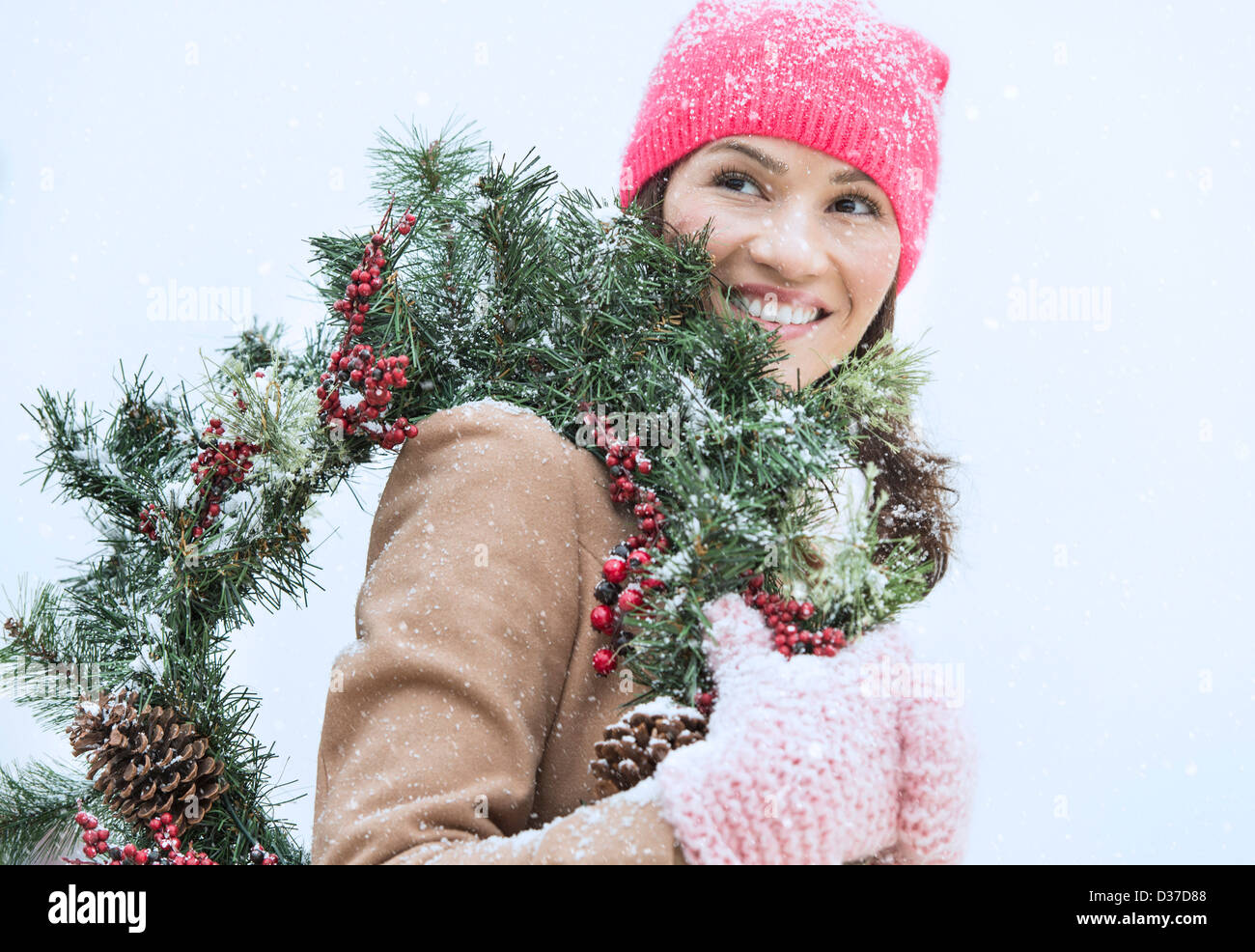 Stati Uniti d'America, New Jersey, Jersey City, ritratto di donna in abiti invernali ghirlanda di trasporto Foto Stock