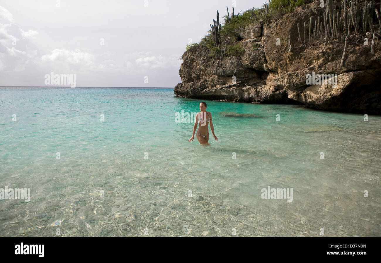 Donna che cammina in acque tropicali Foto Stock