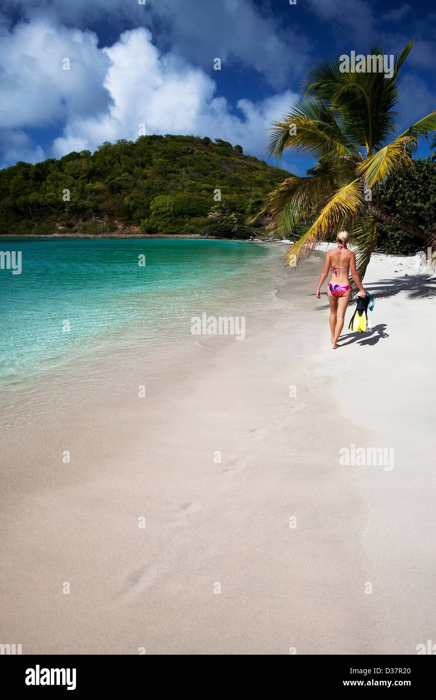 Donna che trasportano le pinne sulla spiaggia tropicale Foto Stock