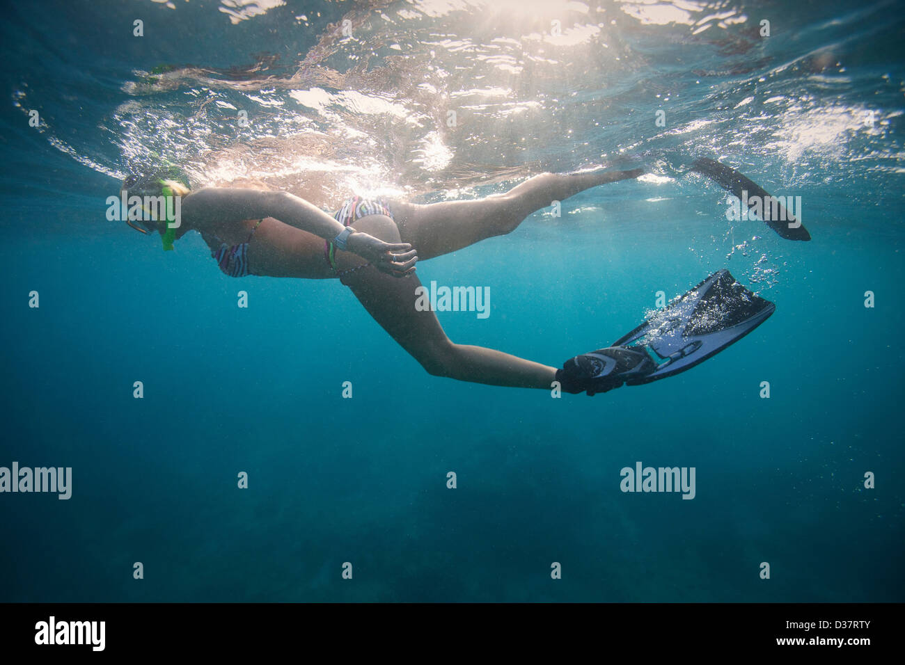 La donna lo snorkeling in acque tropicali Foto Stock