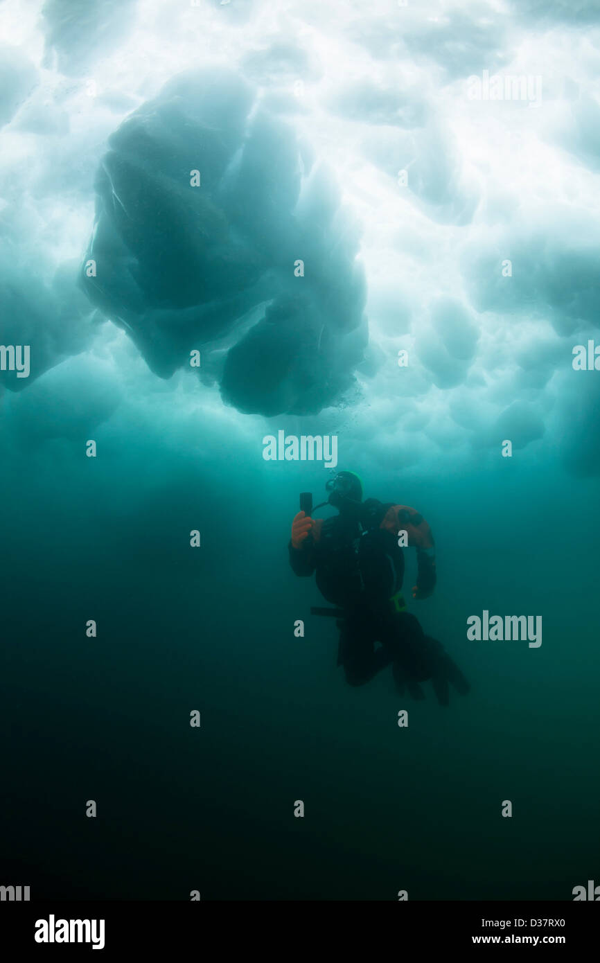 L'uomo scuba diving sotto il ghiacciaio Foto Stock