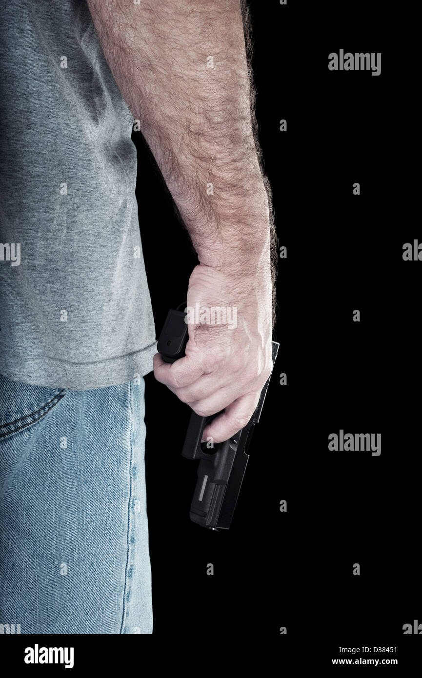 Un uomo porta un semi pistola automatica in cerca di guai. Foto Stock