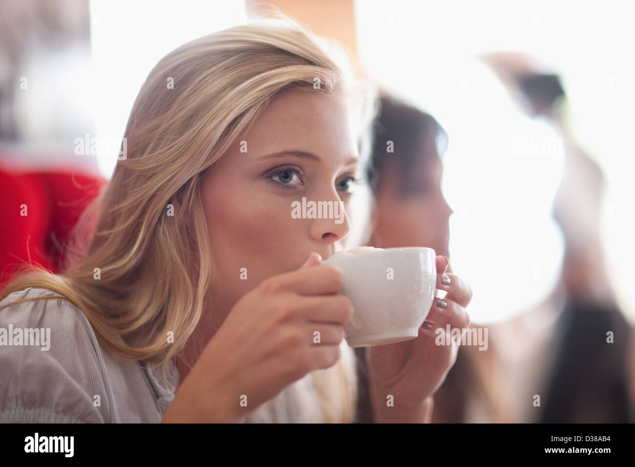 Donna di bere il caffè nella caffetteria Foto Stock