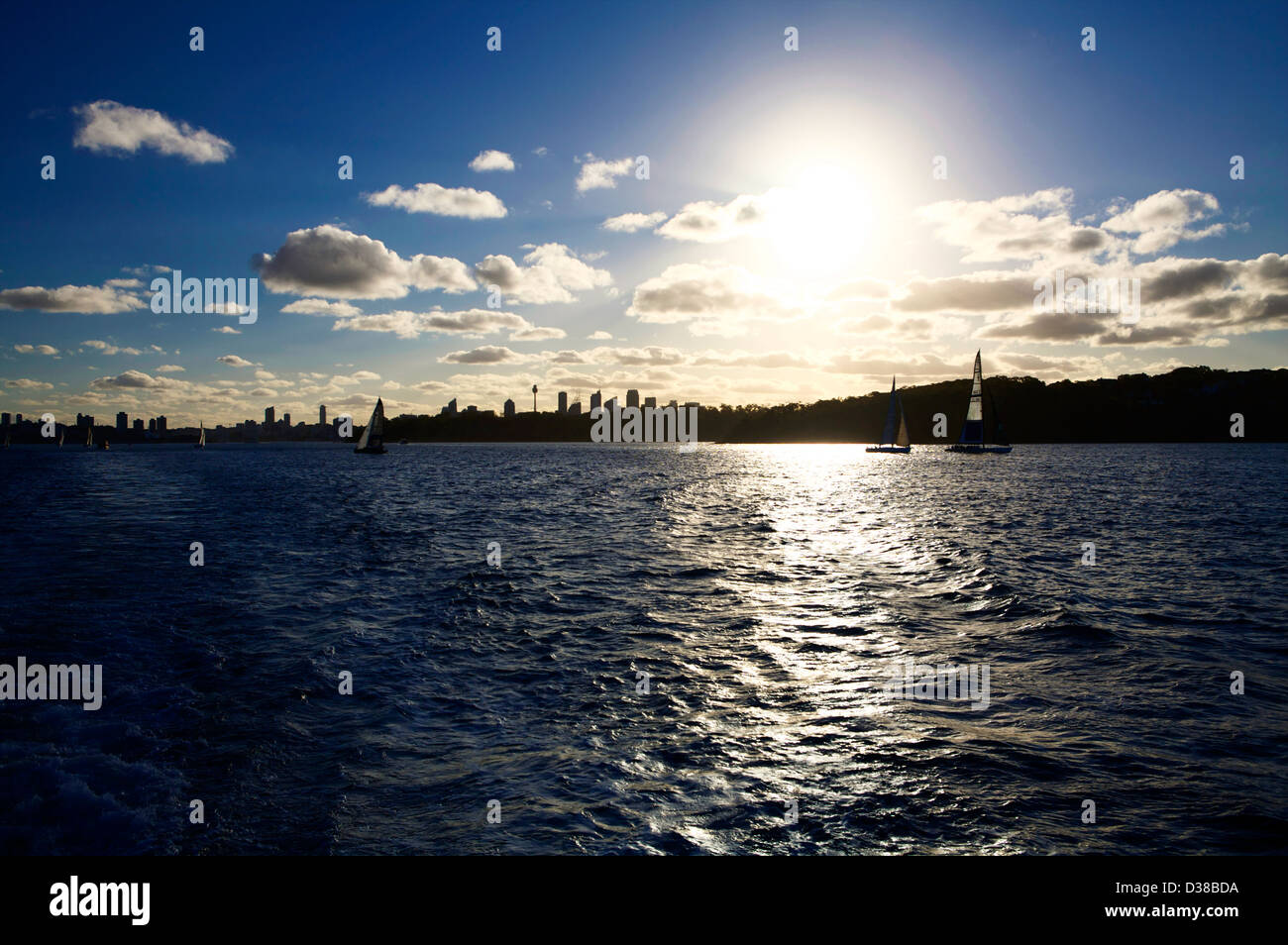 Il Porto di Sydney skyline in silhouette con yacht a vela in acqua al tramonto Foto Stock
