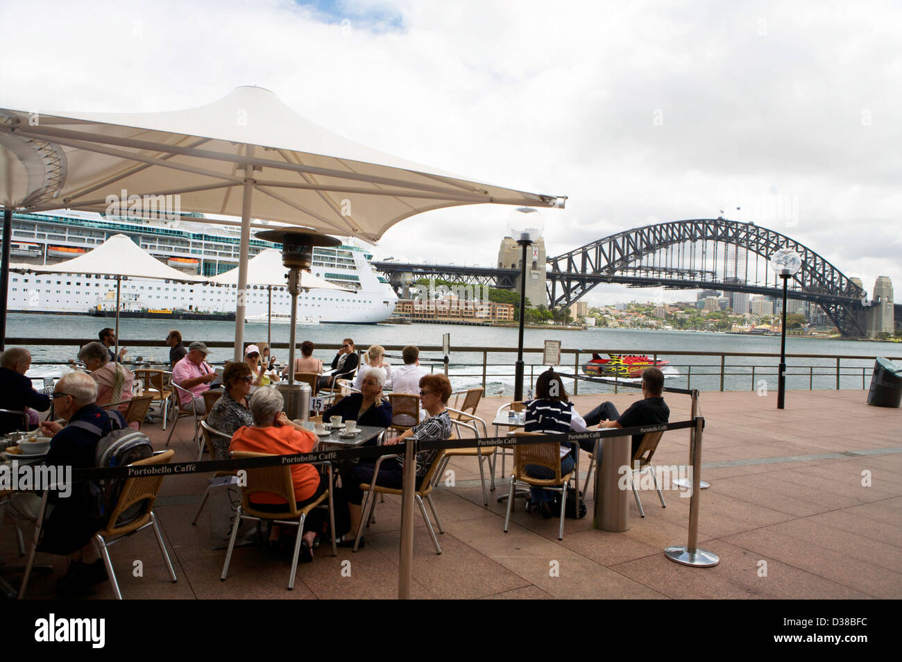 Un grande Ocean Liner ancorata in Sydney Australia dietro le persone aventi il pranzo in vista del Ponte del Porto di Sydney Foto Stock