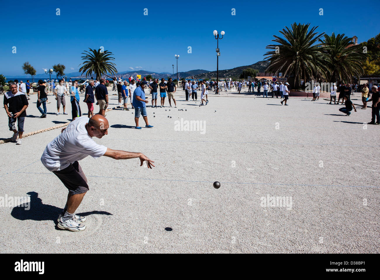 L'uomo giocando a bocce di gettare una boule, Ile-Rousse, Corsica, Francia Foto Stock