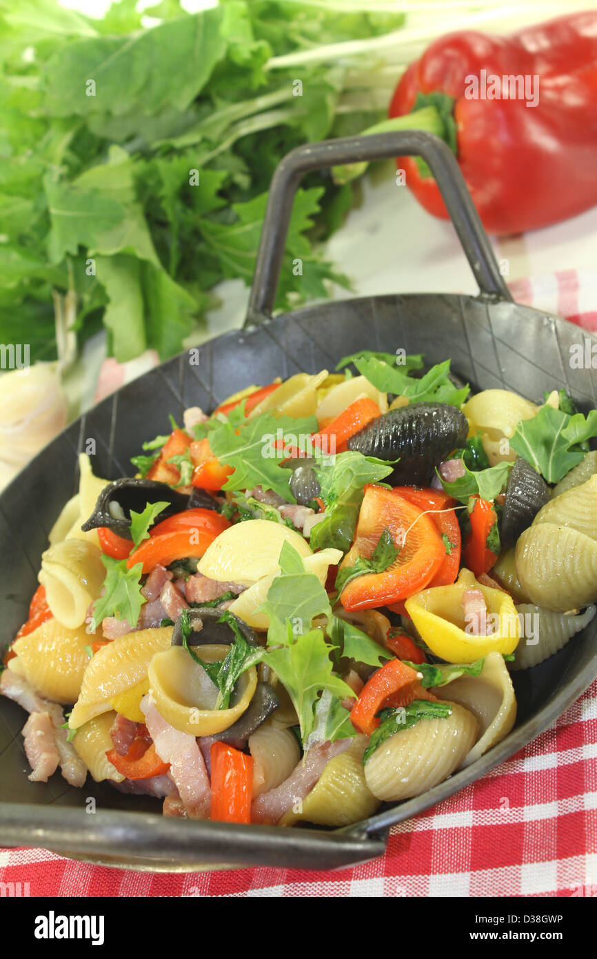 Pasta colorata padella con peperone, cime di rapa, strisce di prosciutto, pomodori e aglio Foto Stock