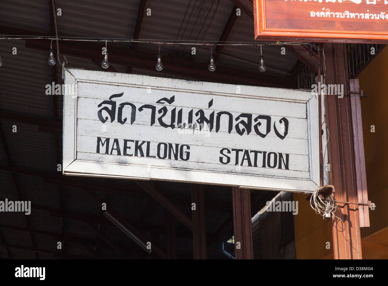 In legno pitturato a segno Maeklong stazione ferroviaria, Thailandia, con il nome della stazione in inglese e thailandese Foto Stock