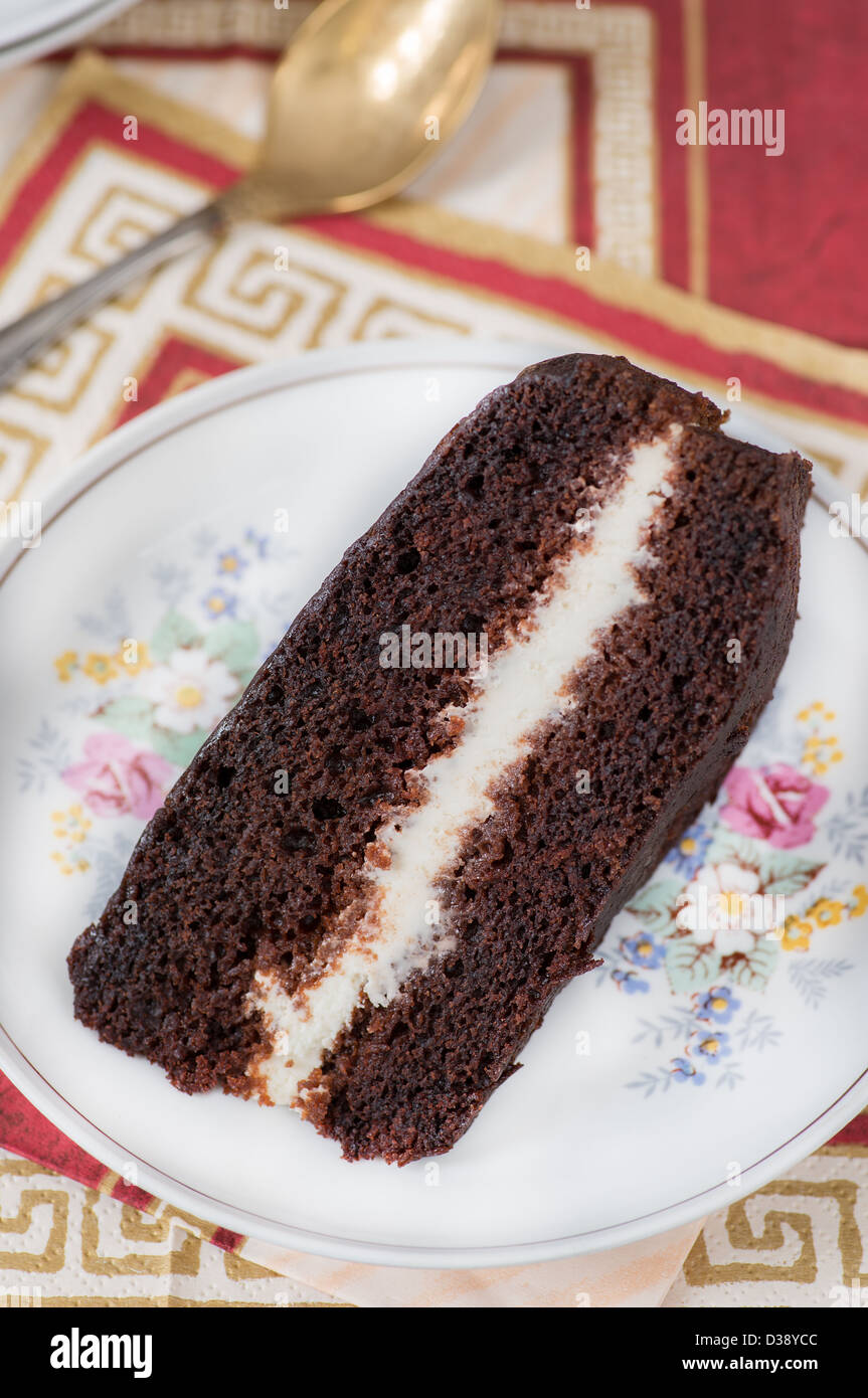 Fetta di umida ricca torta al cioccolato con panna montata Foto Stock