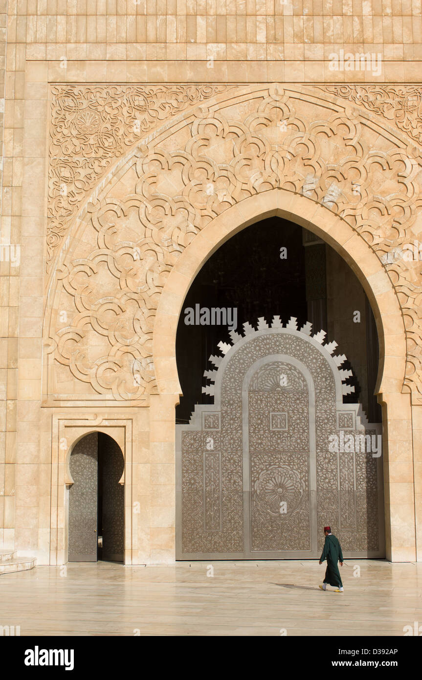 Uomo che indossa un Fez, oltrepassando una delle porte della moschea di Hassan II, Casablanca, Marocco Foto Stock
