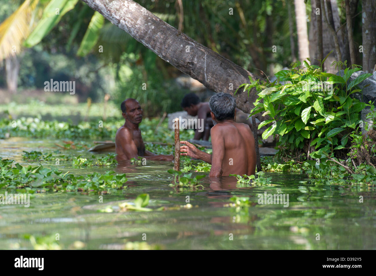 Gli uomini mantenendo la riva del fiume sulle lagune o Alappuzha aka Alleppey in Kerala, nell India meridionale Foto Stock