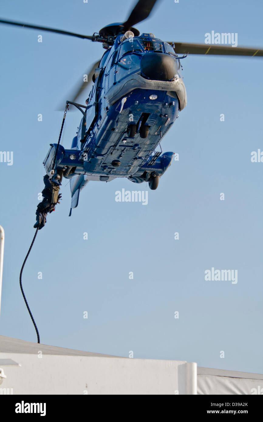 Le forze speciali (SWAT) agente scende sulla corda da un elicottero della polizia (un francese realizzate come 332 L1 Super Puma Euro copter) Foto Stock