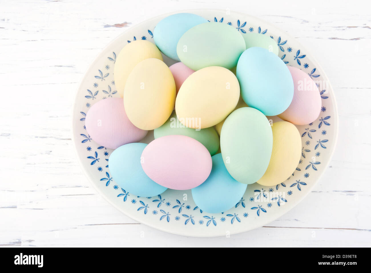 Le uova di pasqua sulla vecchia piastra vintage bianco e lo sfondo in legno Foto Stock
