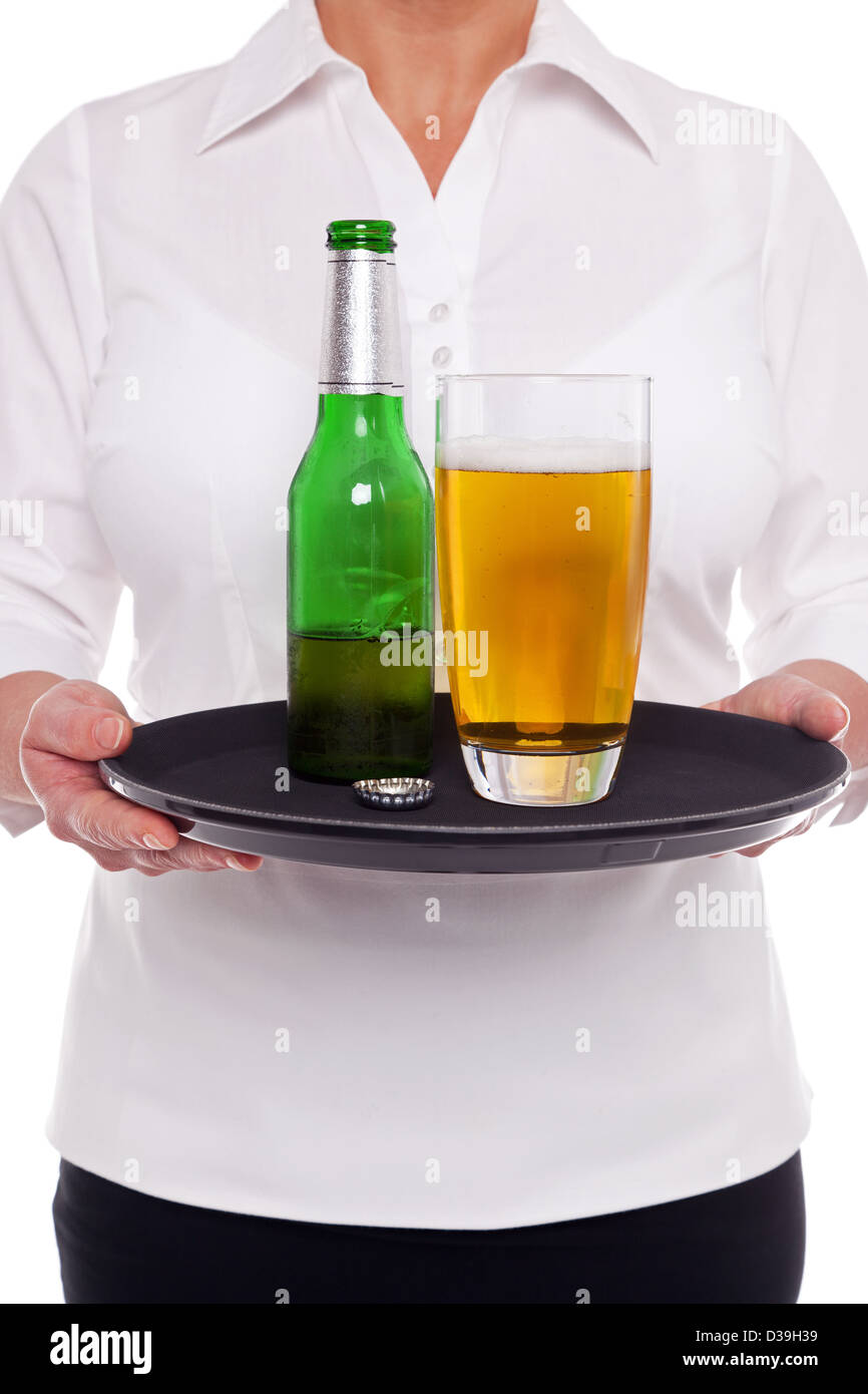 Cameriera tenendo un vassoio con un bicchiere e una bottiglia di birra su di esso, sfondo bianco. Foto Stock