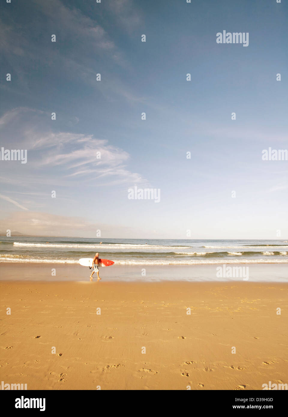 A piedi con tavole da surf su una spiaggia Foto Stock