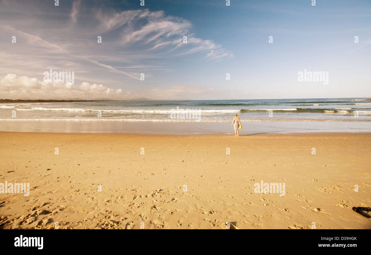 Bambina da sola sulla spiaggia al tramonto Foto Stock