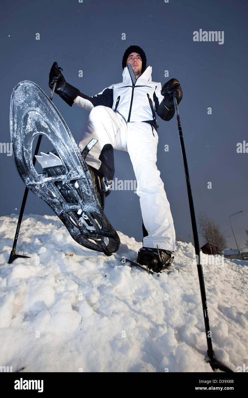 Uomo con le racchette da neve a piedi attraverso la neve, la Lapponia Foto Stock