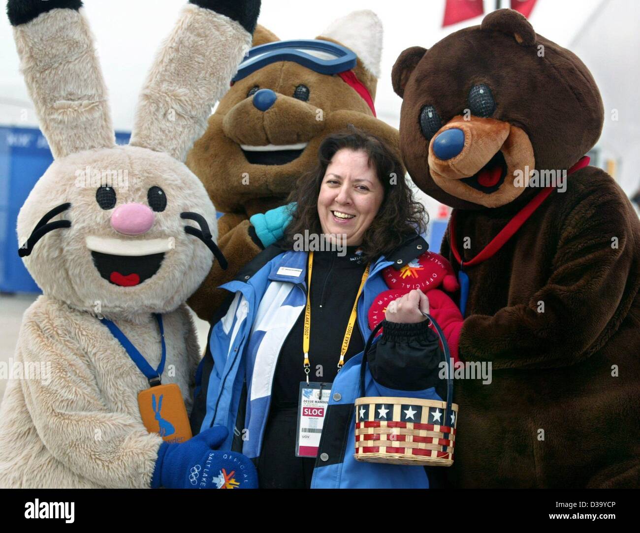 (Dpa) - XIX edizione dei Giochi Olimpici Invernali: tre mascotte olimpiche, (l-r) coniglio " polveri ", coyote "Rame' e recare "carbone", accarezzare volontaria Dessie Manoussa durante il pattinaggio di velocità della concorrenza a Utah Olympic ovale in Salt Lake City, 14.2.2002. Dessie è uno dei 22.000 volontari workin Foto Stock