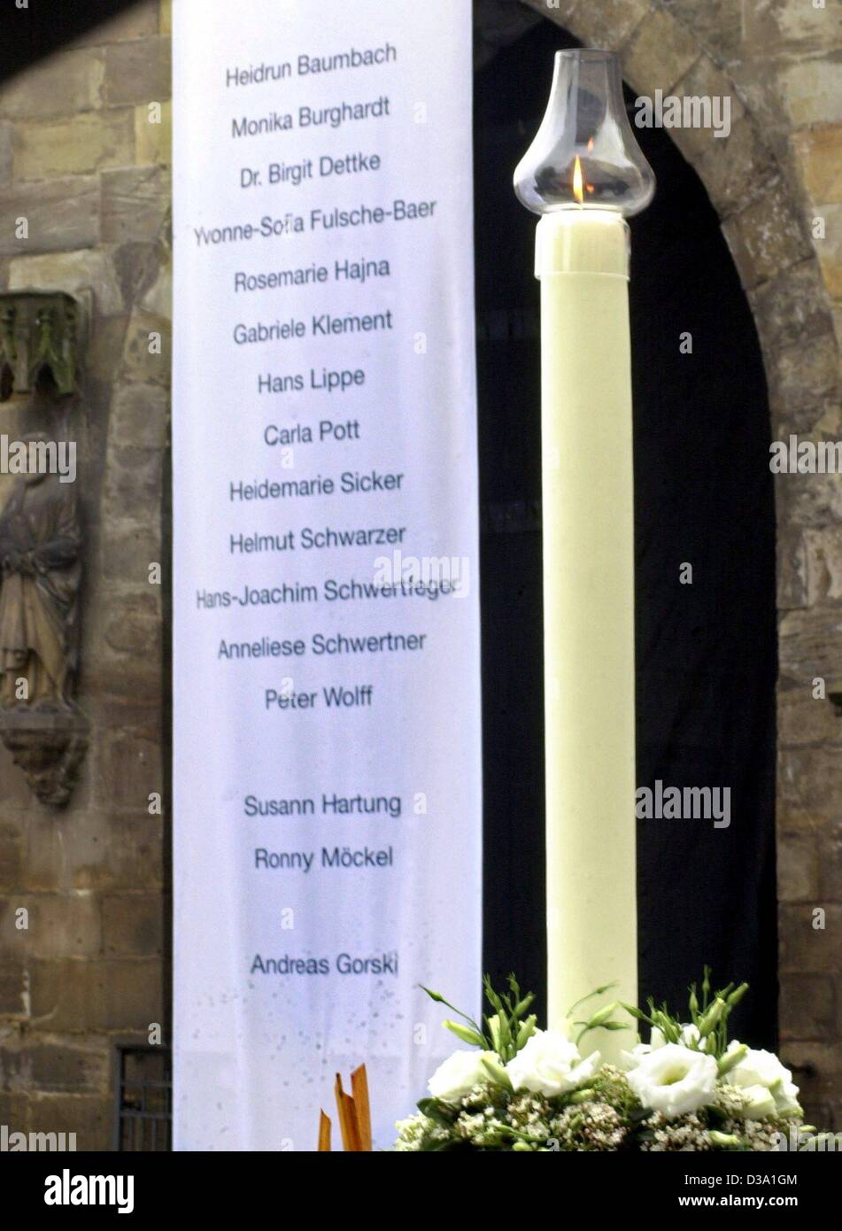 (Dpa) - una candela brucia accanto al banner con i nomi delle vittime di una tragedia amok presso il memoriale di servizio di fronte alla cattedrale di Erfurt, 3 maggio 2002. Una settimana fa un 19-anno-vecchio amok maniac ucciso 16 persone nel suo ex scuola, il Gutenberg high school a Erfurt, prima di iniziare le riprese Foto Stock