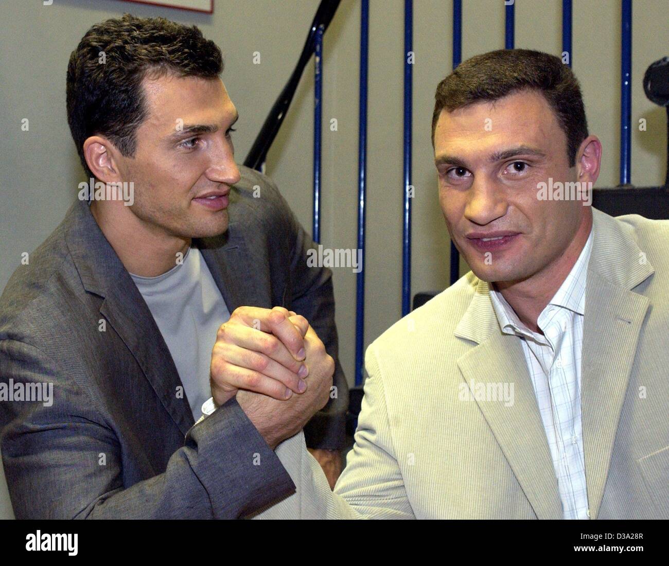 (Dpa) - I fratelli ucraini e world boxing champions, Vladimir (L) e Vitali Klitschko, provare la loro forza contro ogni altro durante la presentazione del loro " Fitness " Libro di Amburgo, 25 luglio 2002. Foto Stock