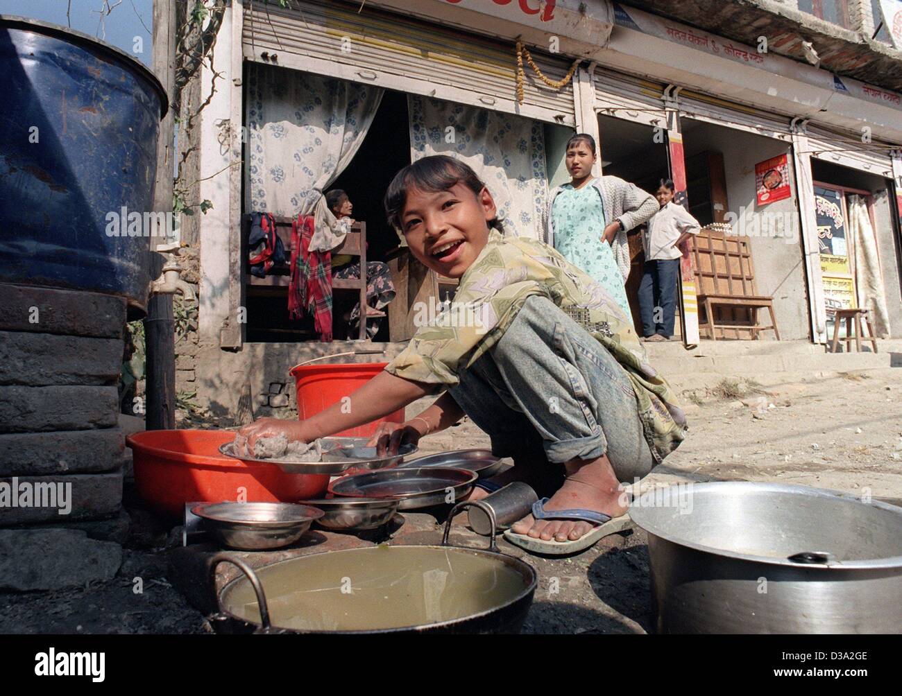 (Dpa) - una ragazza funziona come una lavastoviglie nella baraccopoli di Kathmandu in Nepal, 24 novembre 2000. Unicef cerca di aiutare i bambini a un futuro migliore con l'istruzione scolastica. Foto Stock