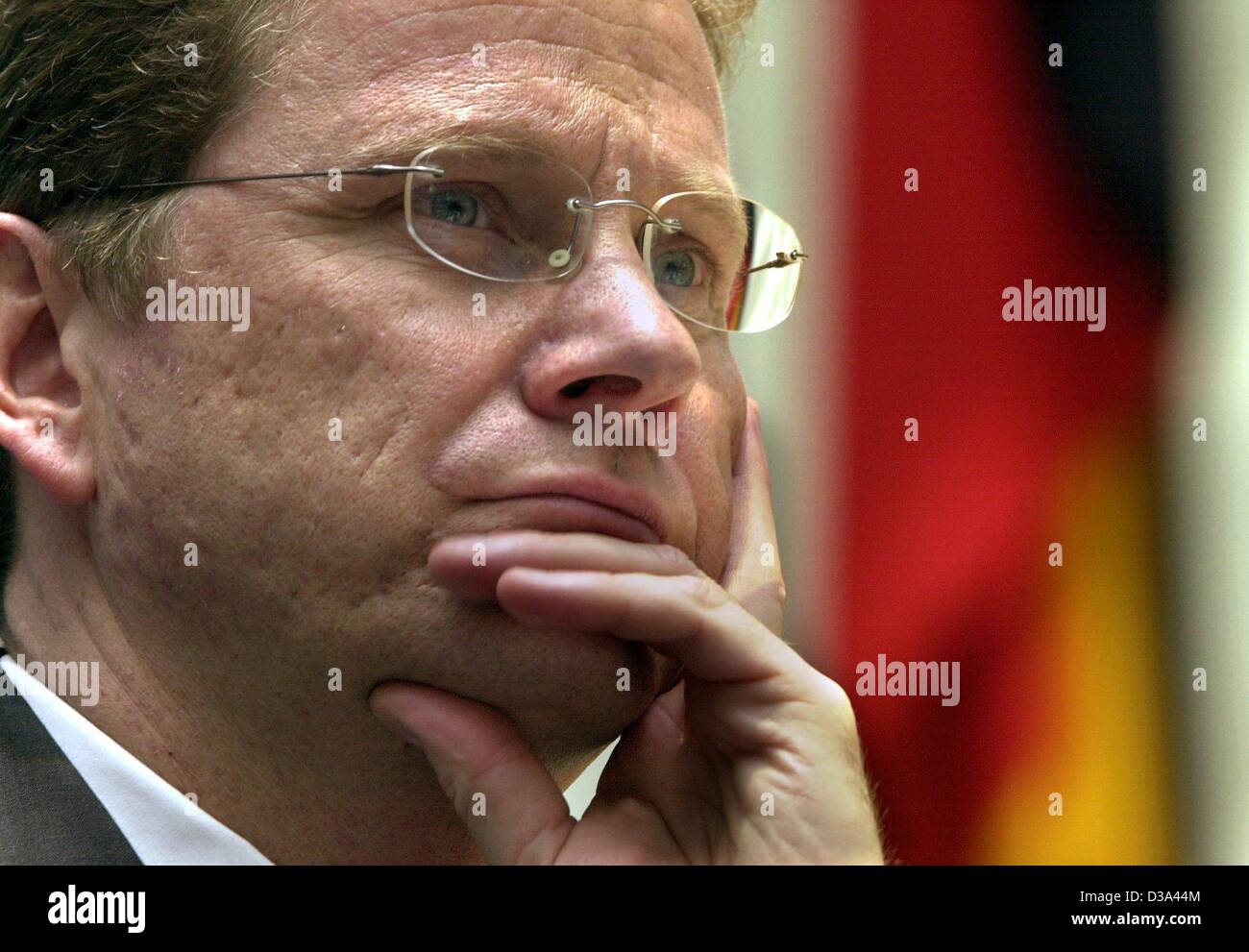 (Dpa) - Guido Westerwelle, Tedesco presidente del partito liberale (FDP), appoggia la sua testa nella sua mano davanti al tedesco bandiera nazionale durante la campagna elettorale del suo partito nella ex Bundestag di Bonn (Germania), 7 luglio 2002. Foto Stock