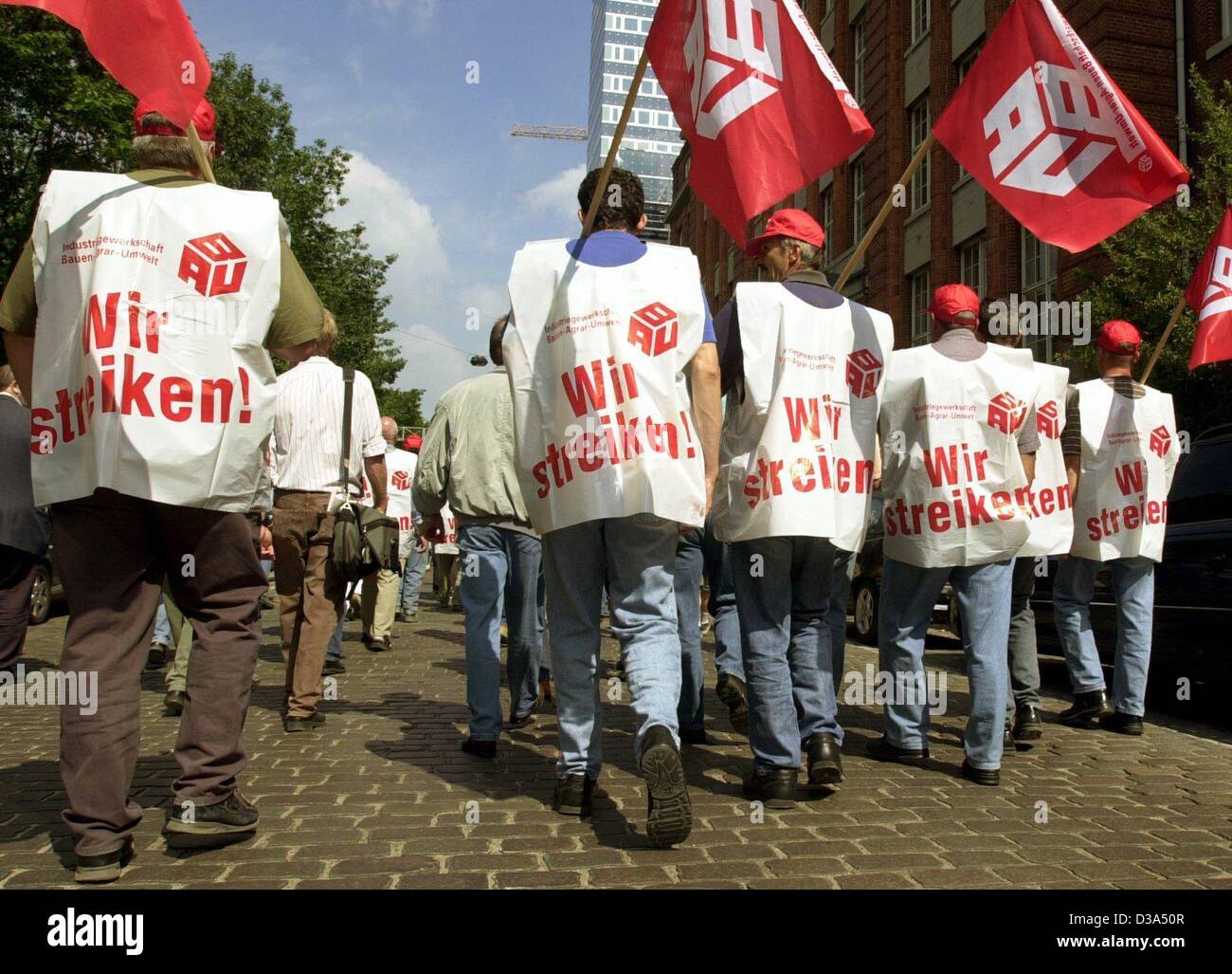 (Dpa) - lavoratori edili marzo con plastica giubbotti di sciopero e unione bandiere per un sito di costruzione ad Amburgo, Germania, 17 giugno 2002. È il primo sciopero a livello nazionale nel settore della costruzione in Germania del dopoguerra. Il sindacato è stato in parla di un 4,5 per cento aumento dei salari con i datori di lavoro Foto Stock
