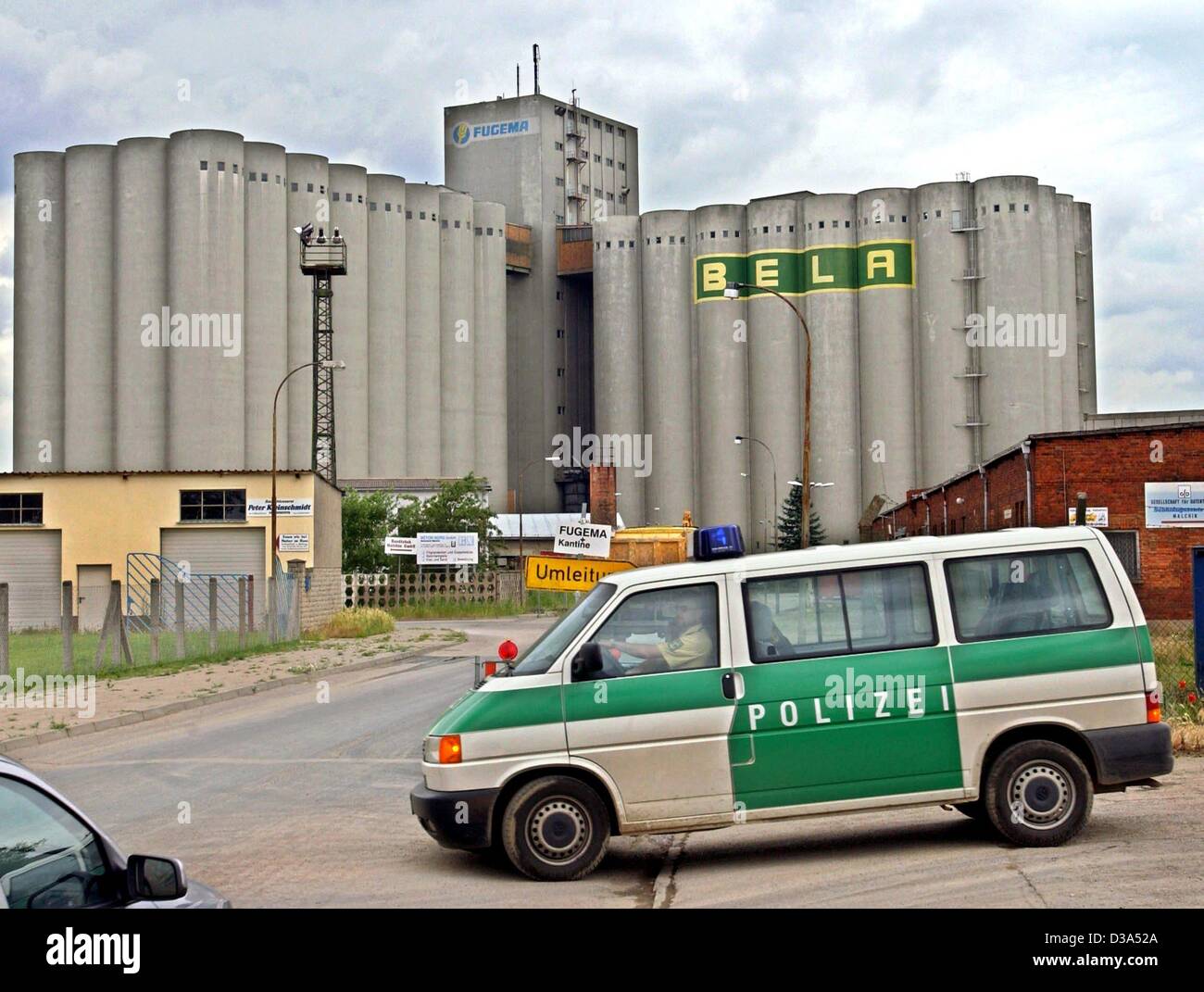 (Dpa) - Un auto della polizia passa di fronte all'impianto di produzione dei mangimi per animali produttore Fugema in Malchin, Germania orientale, 13 giugno 2002. Nel dicembre 2001 la fabbrica aveva comprato 72 tonnellate di grano, che era stato memorizzato in un ex magazzino di nitrofene, per la produzione di mangimi per polli, mucche e maiali. E Foto Stock (Dpa) - Un auto della polizia passa di fronte all'impianto di produzione dei mangimi per animali produttore Fugema in Malchin, Germania orientale, 13 giugno 2002. Nel dicembre 2001 la fabbrica aveva comprato 72 tonnellate di grano, che era stato memorizzato in un ex magazzino di nitrofene, per la produzione di mangimi per polli, mucche e maiali. E Foto Stock