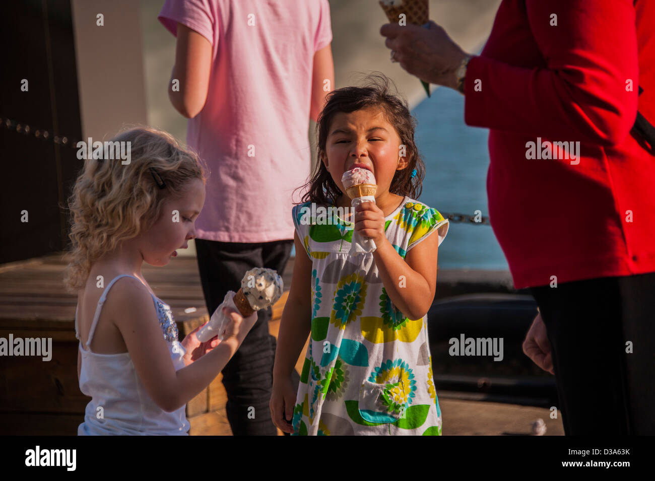 Due ragazze di mangiare il gelato in Chicago il Navy Pier park nel sole di primavera Foto Stock