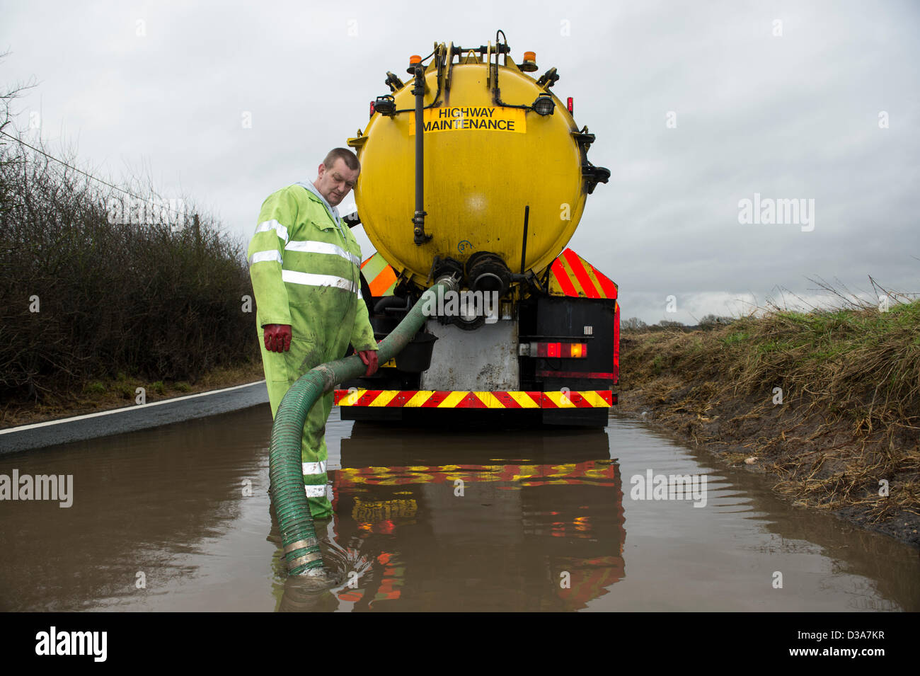 Hullbridge, Essex, Regno Unito. 14 febbraio 2013. Blackspot tristemente famoso per le alluvioni, tofu Lane, è stato allagato per quasi tre mesi. Il Consiglio ha dichiarato questo andrà a tempo indeterminato in modo imprenditore locale e Consigliere Rettendon Roy Hart ha finanziato la cancellazione della strada e scarichi interrati se stesso. Le sue attività sono state colpite dalla chiusura della strada. Il Consiglio ora hanno unito gli sforzi per liberare la strada e scarichi. Il contraente per Essex County Council il pompaggio di acqua dalla strada in una petroliera. Allsorts Stock Photo/Alamy linea di credito News: Allsorts Stock Photo / Alamy Live News Foto Stock