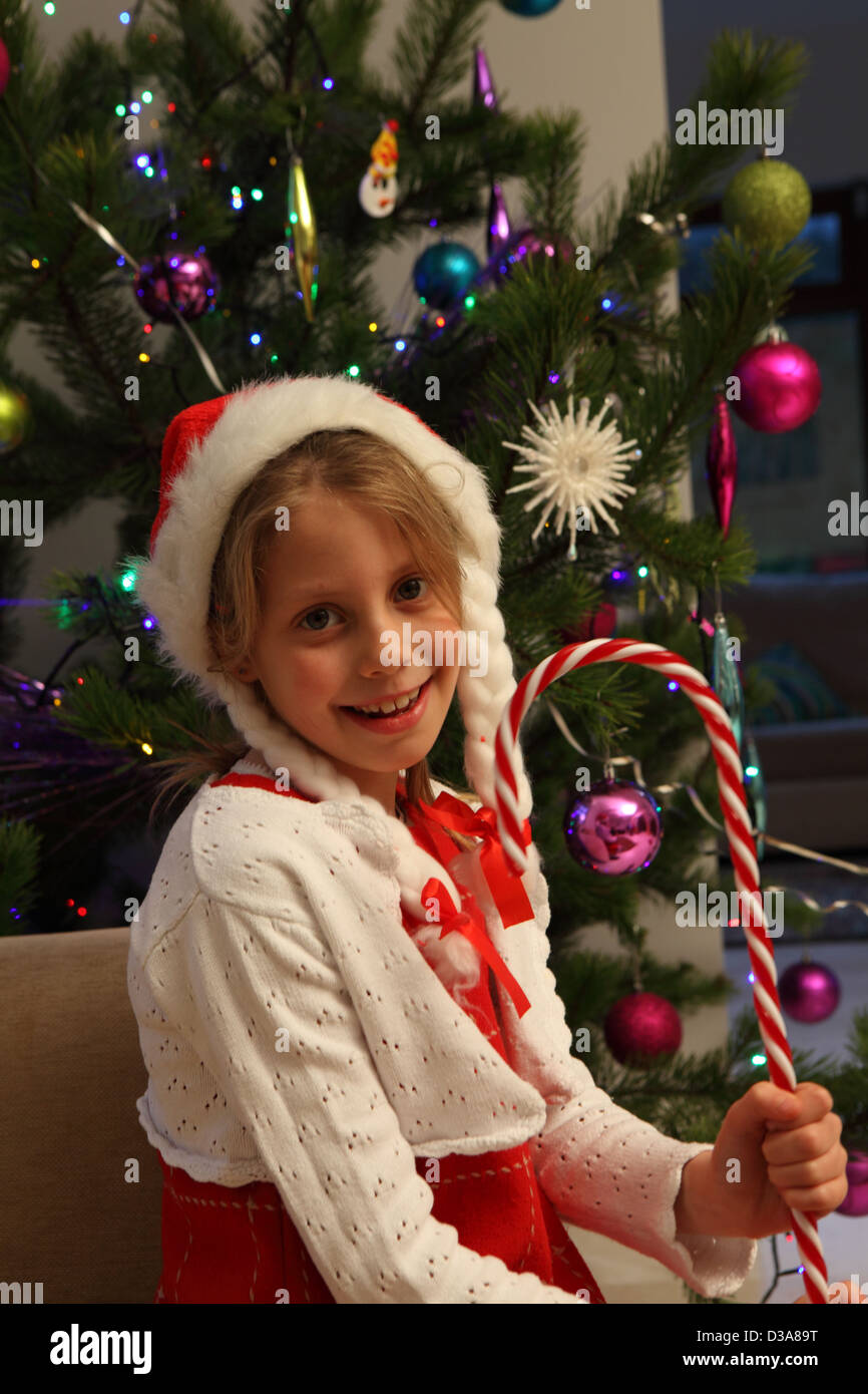 Ragazza indossando Santa hat da albero di Natale Foto Stock