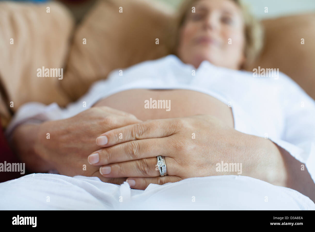 Donna incinta rilassante sul divano Foto Stock