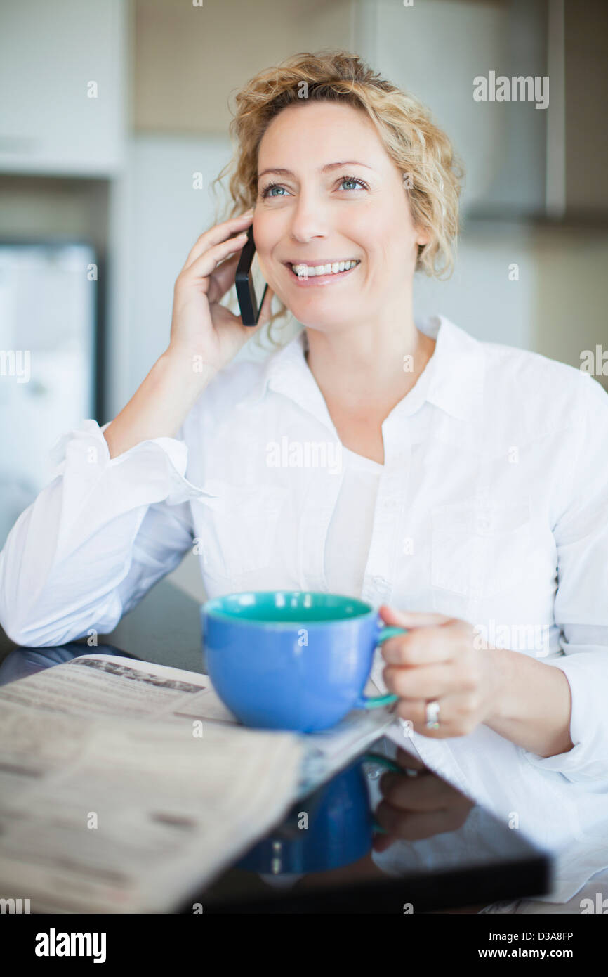 Donna con caffè parlando al telefono Foto Stock