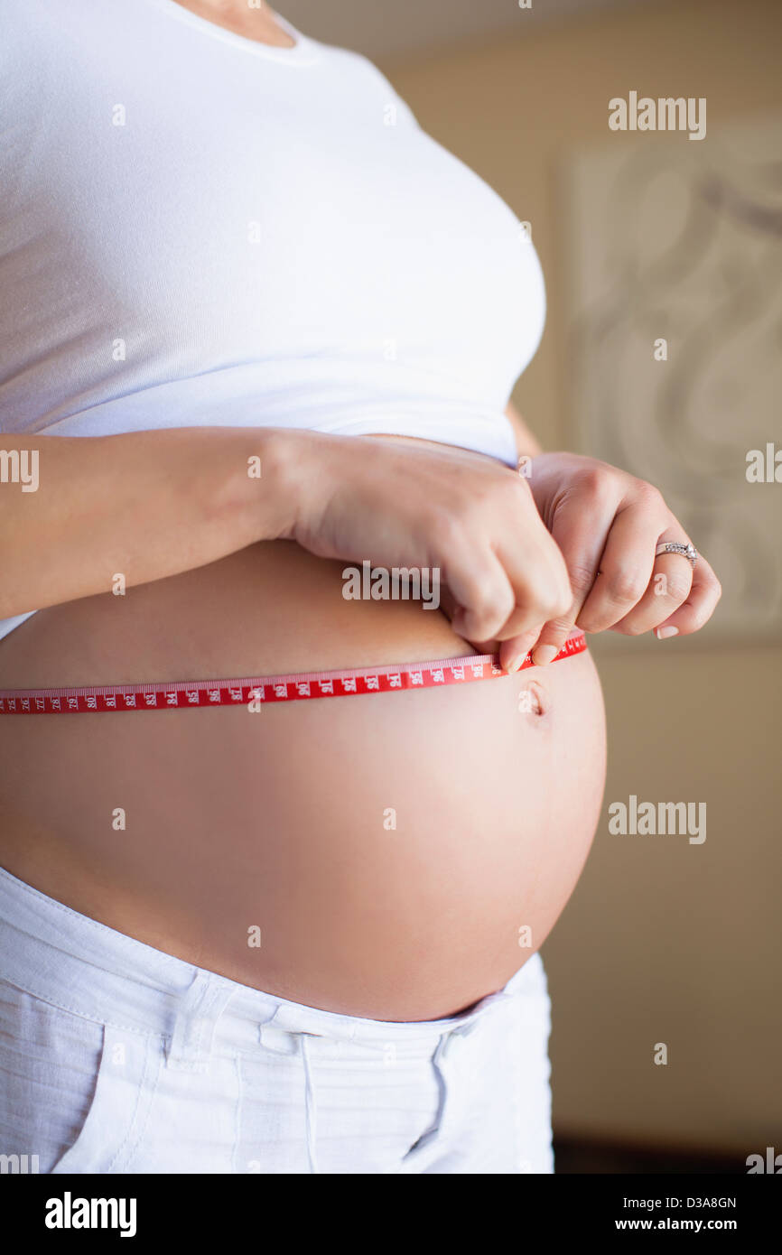 Donna incinta pancia di misurazione Foto Stock