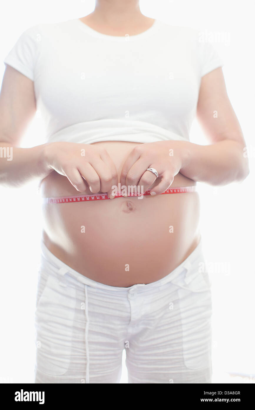 Donna incinta pancia di misurazione Foto Stock