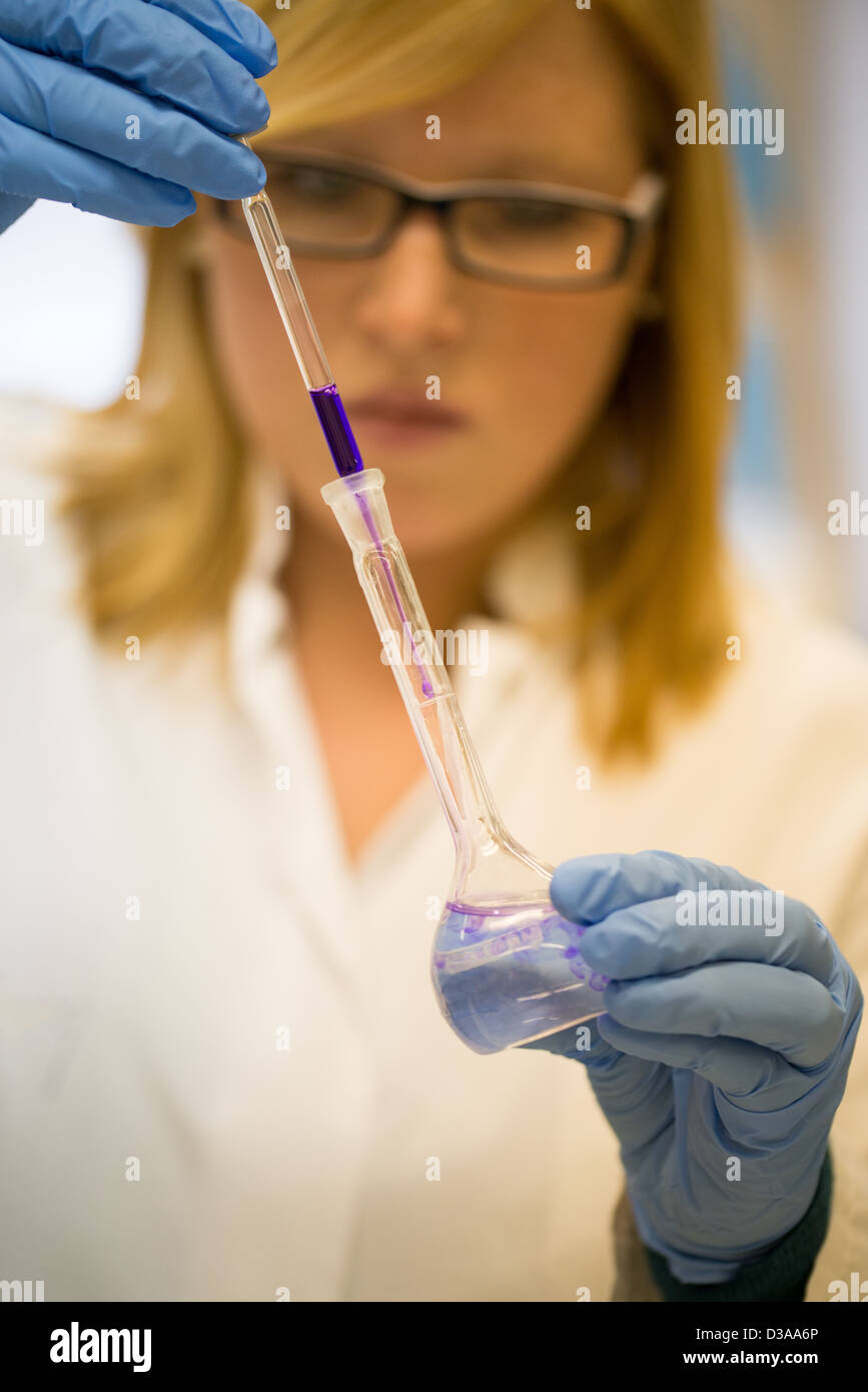 Giovani donne scienziato in laboratorio universitario funziona con liquidi colorati Foto Stock