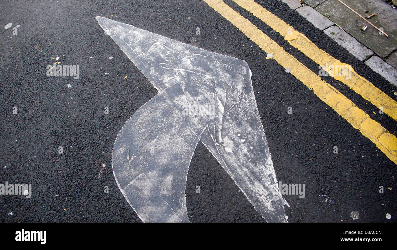 Freccia dipinta in strada Foto Stock