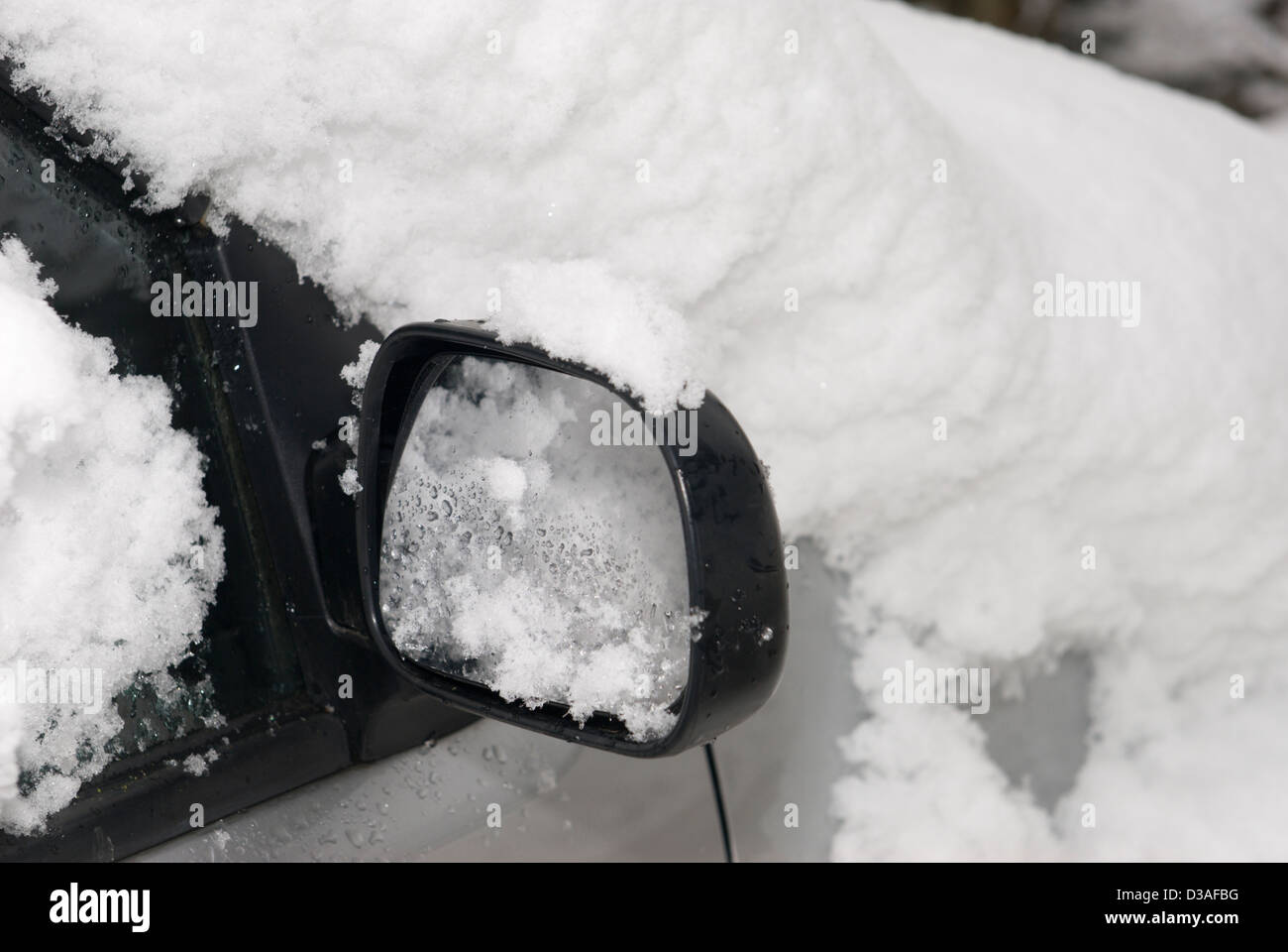 Close up dettaglio di uno specchietto laterale su un auto coperti di neve Foto Stock