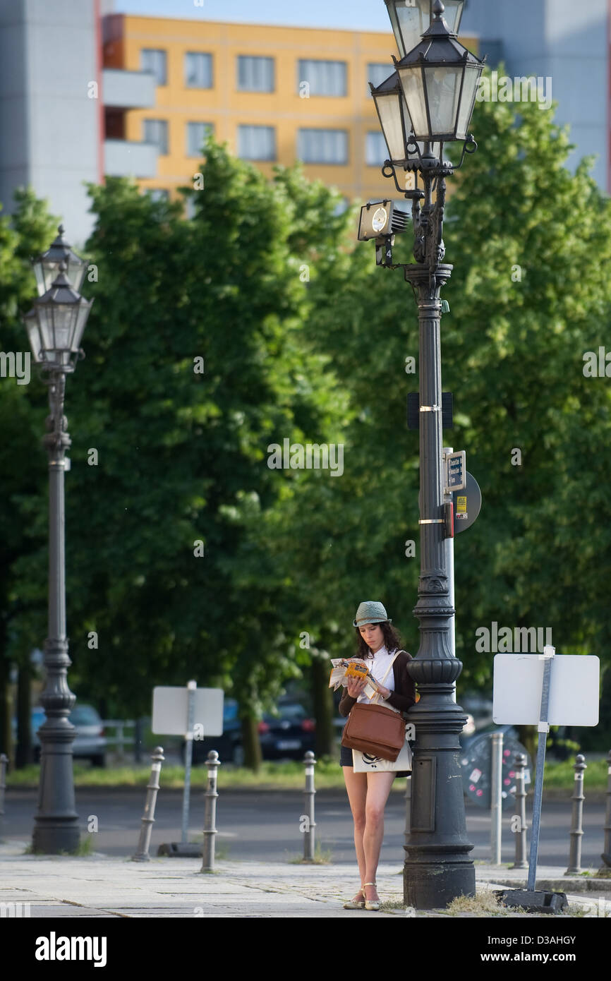 Berlino, Germania, turistico appoggiata contro una vecchia lampada a gas e studiato la mappa Foto Stock