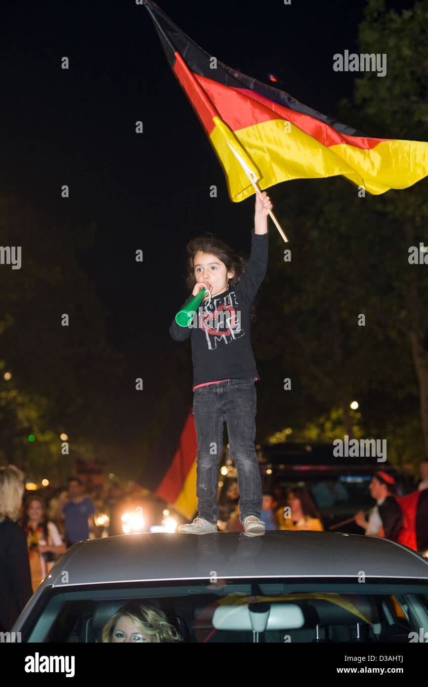 Berlino, Germania, una ragazza fatta oscillare sul tetto di un'automobile la bandiera della Germania Foto Stock