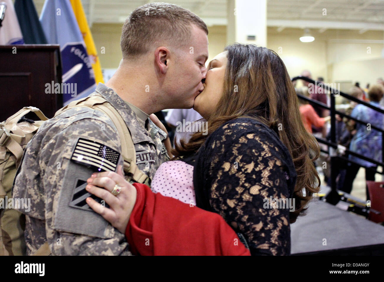US Army Sgt. Corbett Futral baci di sua moglie Jessica dopo il ritorno da nove mesi di distribuzione per il Kuwait Febbraio 14, 2013 a Fort Benning, GA. Più di 300 soldati sono stati riuniti con la famiglia e gli amici appena in tempo per festeggiare il giorno di San Valentino. Foto Stock