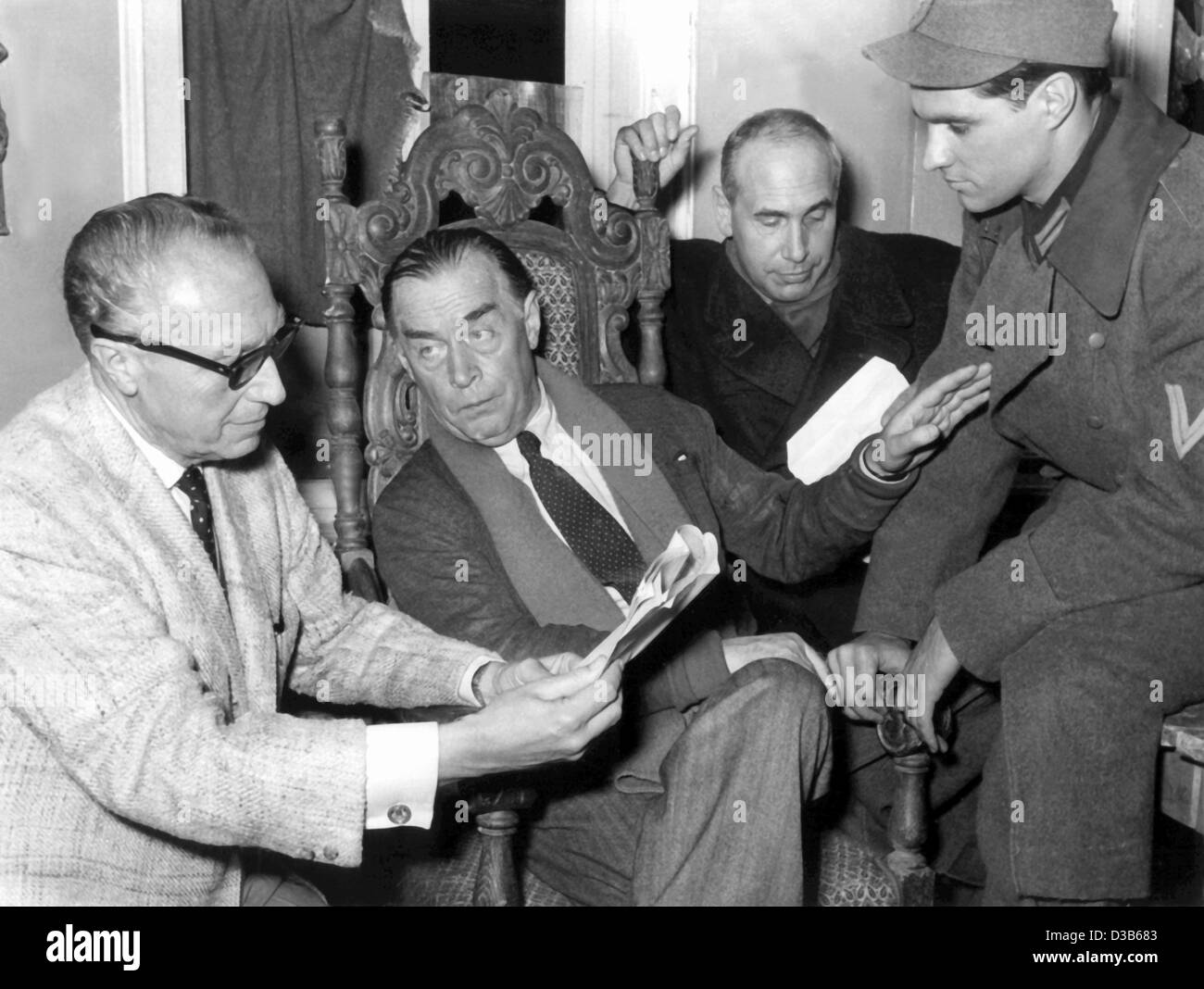 (Dpa file) - L-R: Tedesco Hollywood director Douglas Sirk, romanziere tedesco Erich Maria Remarque, attore tedesco Charles Regnier e attore statunitense John Gavin discutere una scena durante le riprese di 'un tempo per amare e un tempo per morire" di Berlino, 10 ottobre 1957. Erich Maria Remarque ("Tutto tranquillo sulla Western Foto Stock