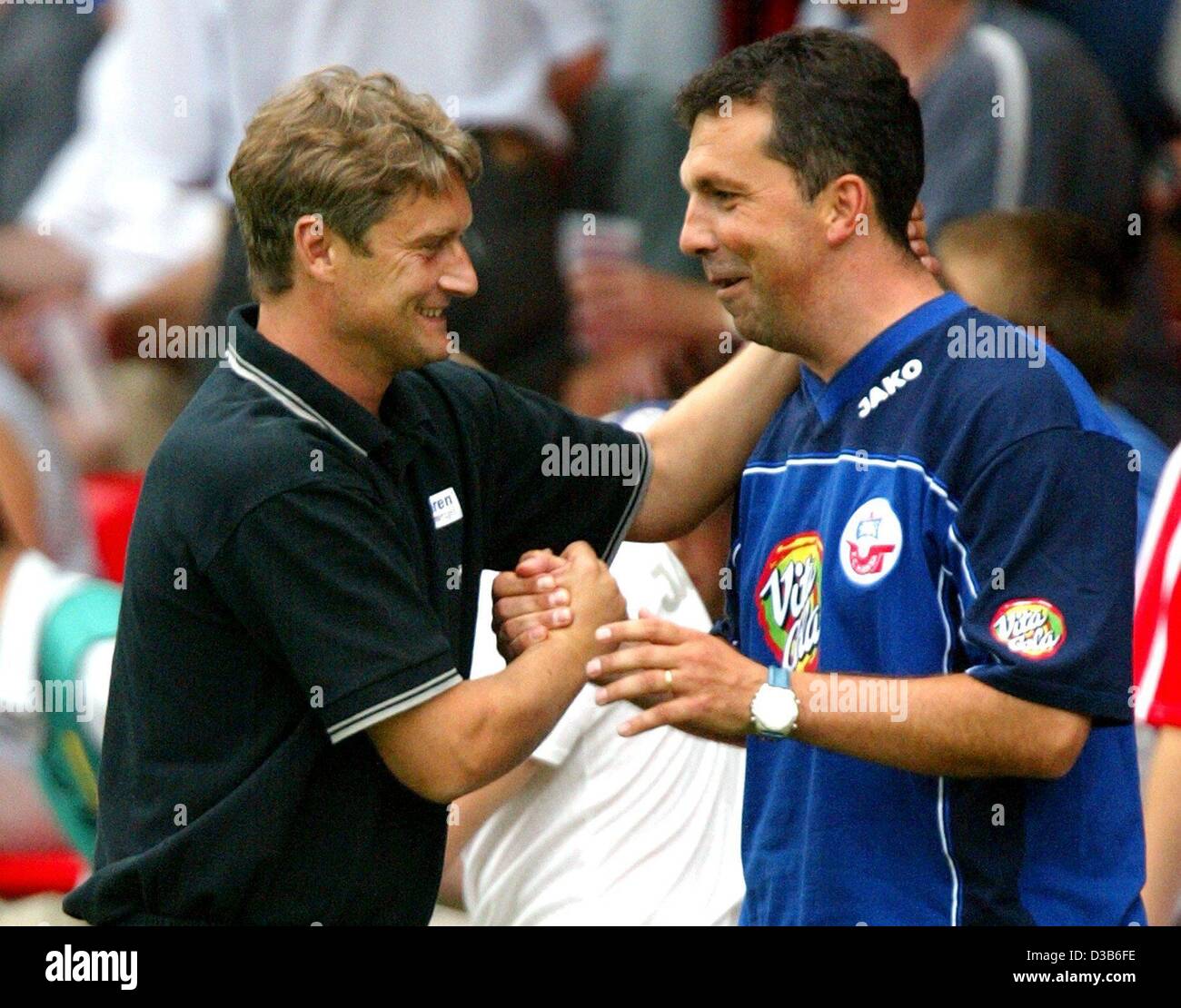 (Dpa) - Rostock's soccer coach Armin Veh (L) abbraccia il suo assistente Juri Schluenz dopo la loro squadra ha vinto la partita FC Hansa Rostock contro FC Energie Cottbus a Cottbus, Germania, 24 agosto 2002. Rostock ha vinto 4:0, rimanendo così secondo in classifica. Foto Stock