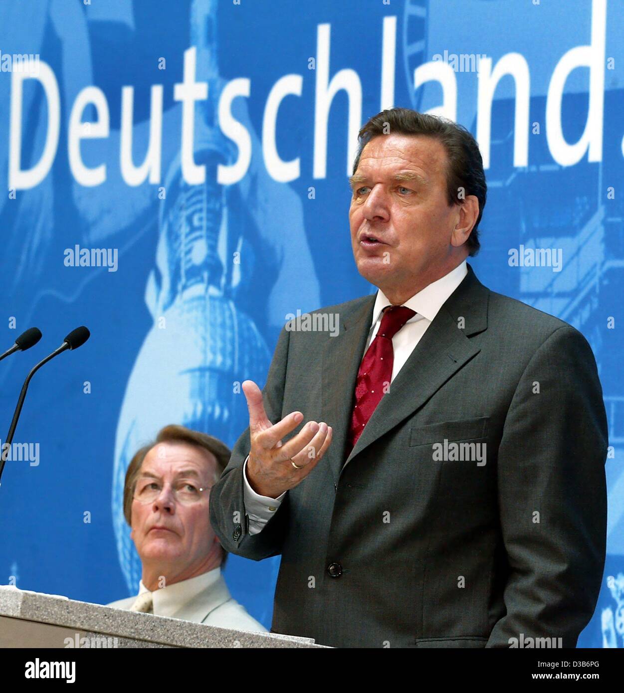 (Dpa) - Il cancelliere tedesco Gerhard Schroeder parla come egli sta di fronte alla scrittura di 'Deutschland' durante una conferenza di partito a Berlino, 18 agosto 2002. In background Franz Muentefering, Segretario Generale del tedesco il Partito socialdemocratico (SPD). Nel suo discorso di Schroeder ha sostenuto la Hartz Foto Stock